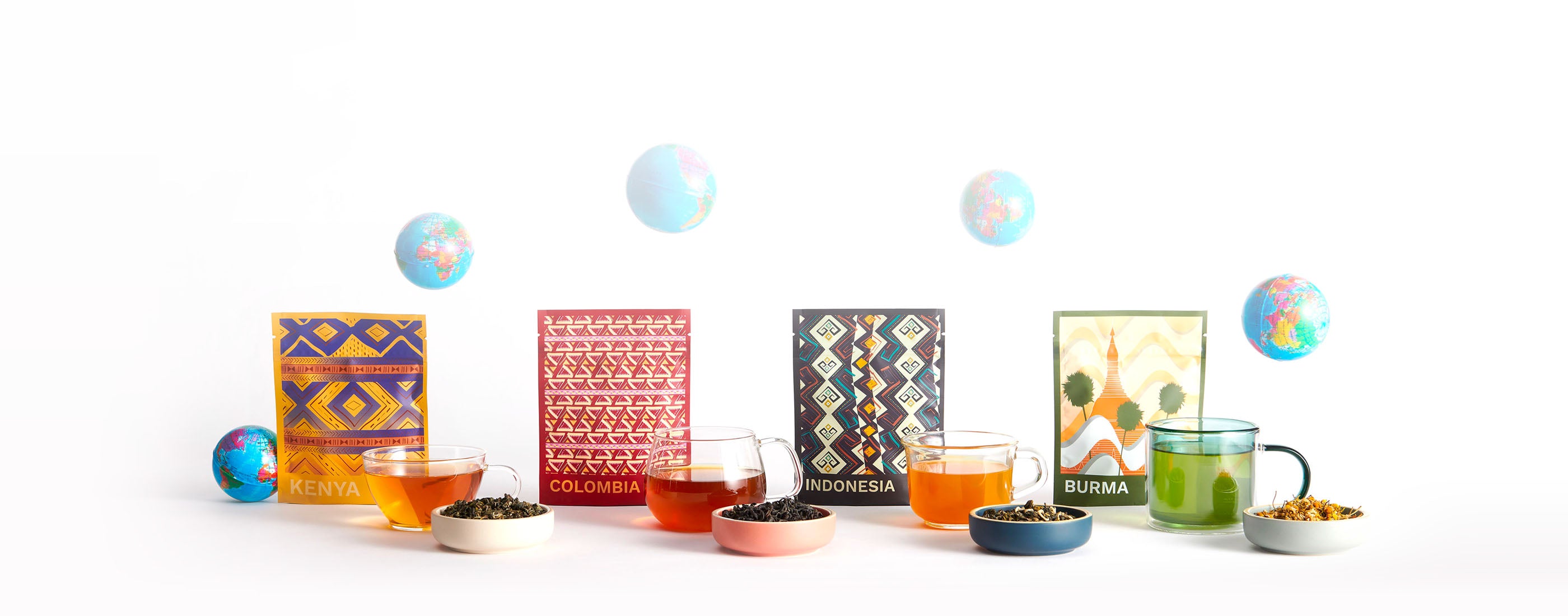 An assortment of teas in colorful patterned packaging next to cups of tea