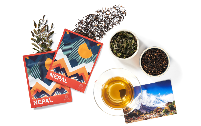 a subscription box including two bags of loose leaf tea and a postcard