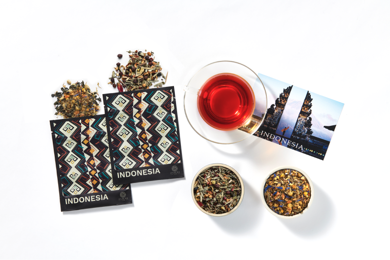 a subscription box including two bags of loose leaf herbal tea and a postcard